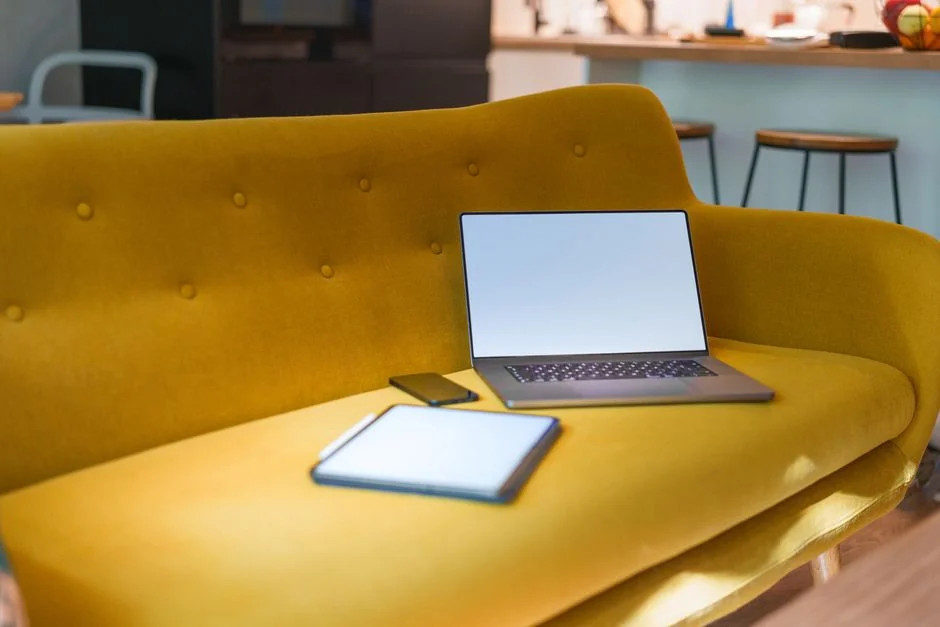 Un homme retouche une image de fruit sur un MacBook Pro, assis dehors sur l’herbe.